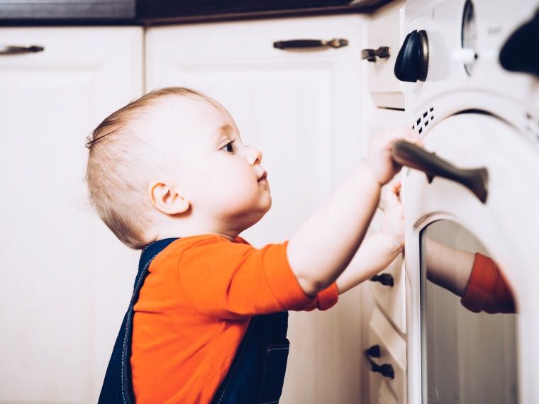 Baby grasping oven door handle